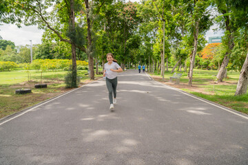 A happy little girl runs along a path in a park