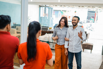 couple of customers came in to be greeted by two shop assistants when going to see the furniture products © Odua Images