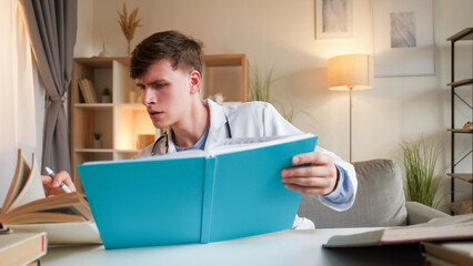 Healthcare studying. Medical knowledge. Smart focused doctor man in clinic white uniform reading book information for professional development at workplace.