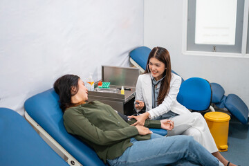 Smiling female doctor checking a patient's blood pressure in hospital room