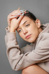 Fototapeta premium Pensive thoughtful young girl wearing sweatshirt with hood