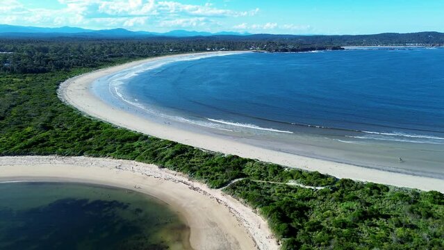 Drone aerial landscape white sands bay ocean waves coastline bushland Broulee beach Mossy Point Tomakin South Coast Australia