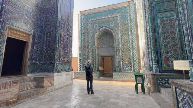 Man Admires Mausoleum of Khoja Ahmad at Shah-i-Zinda, Samarkand, Uzbekistan; 4K Footage Highlights Persian-Mongolian Architecture, Vibrant Tiles, and Silk Road History in a UNESCO Site.