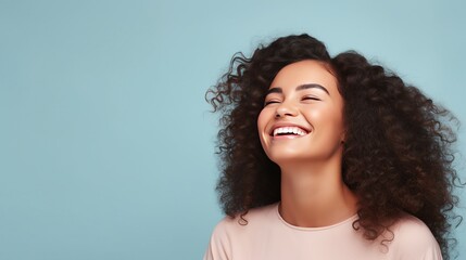 Capture the joy and warmth of a young woman's smile as she stands against a pastel flat background, providing perfect copy space