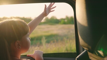 child girl face looks smiling from car out window, cinematic, travel, active, child pulls happy...