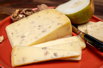 Piece of Dutch Gouda cheese made from cow milk with added walnuts close up
