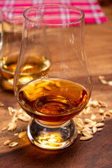 Tasting of different Scotch whiskies strong alcoholic drinks, drum of whiskey and colorful Scotch tartan on background close up