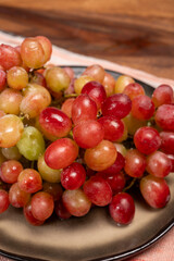 Sweet washed ripe pink grapes berries on board ready to eat