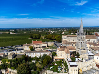 Fototapeta premium Aerial views of green vineyards, old houses and streets of medieval town St. Emilion, production of red Bordeaux wine on cru class vineyards in Saint-Emilion wine making region, France, Bordeaux