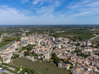 Fototapeta premium Aerial views of green vineyards, old houses and streets of medieval town St. Emilion, production of red Bordeaux wine on cru class vineyards in Saint-Emilion wine making region, France, Bordeaux