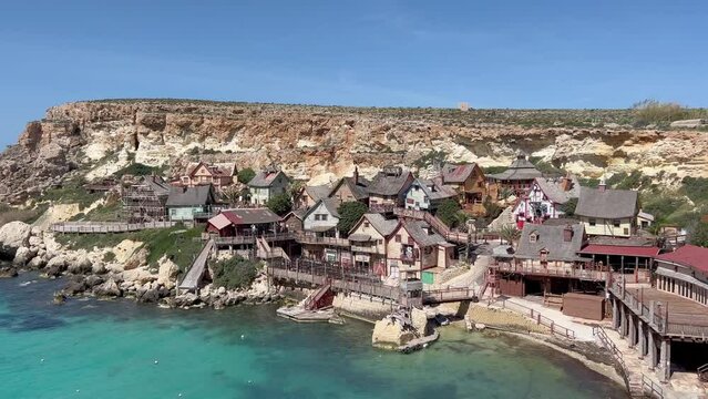 Popeye Village, Malta: 4K Reveal of Cinematic Set, Unique Architecture, and Turquoise Waters. Film history meets vibrant charm in this iconic destination.