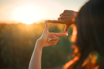 Closeup of woman hands making frame gesture with sunset, Female capturing the sunrise. Future...