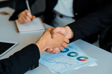 Business people agreement concept. Businessman and Asian businesswoman do handshake in the office. uds