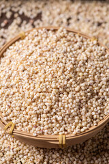 Sorghum seeds in bamboo basket closeup. Whole seeds of Sorghum Moench