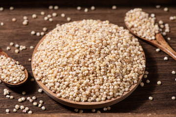 Sorghum seeds in plate on wooden table. Whole seeds of Sorghum Moench
