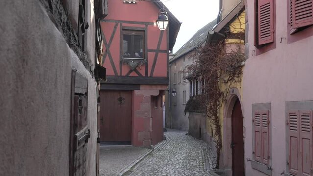 Scenic small cobblestone streets in medieval french village kaysersberg with half-timbered architectural buildings.