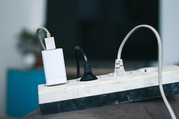Electrical extension cord with different plugs and phone charger at home