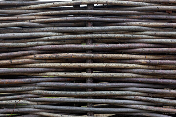 Part of a fence made of wooden branches. Aesthetics and ecology. Space for text. Background.