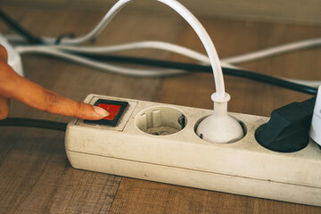 Finger shut down an electrical plug with push the switch. Saving energy consumption concept 
