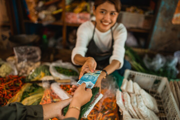hand of customer giving cash money to groceries seller