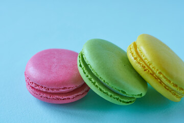 Colorful macaroons on blue background. Close-up.