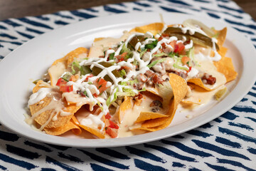 Carne Asada Nachos with sour cream, queso and tomatoes