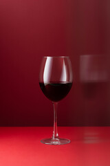 Glass of red wine on a red background art photography