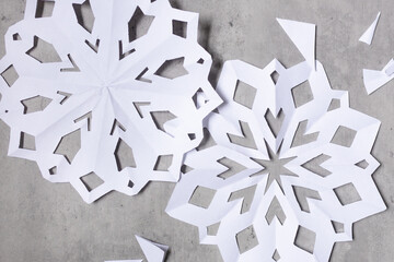 flat lay of white paper snowflakes and paper scraps