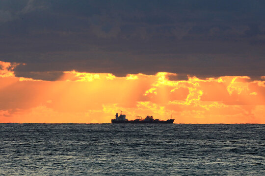 commercial shipping with sunrise and dark clouds