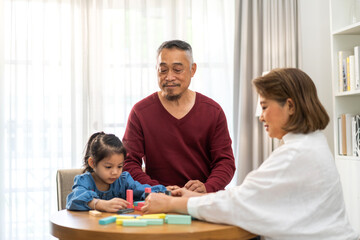 Obraz premium Portrait of happy love asian grandfather with grandmother and asian little cute girl enjoy relax at home.Young girl with their laughing grandparents smiling together.Family and togetherness