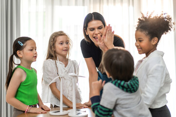 Portrait happy teacher help school children student having fun activity learn play renewable energy from solar windmill, education, science, environment, Eco, wind turbines, class at elementary school