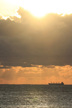 commercial cargo shipping in the sun and dark clouds