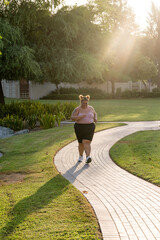 Portrait of a plump woman exercising outdoors doing brisk walking