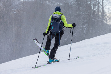 Ski touring, a person is performing a 45 degree turn while walking uphill with skis, modern...