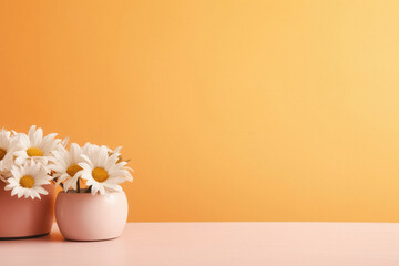 Bouquet of beautiful chamomiles in vase on table against orange background.