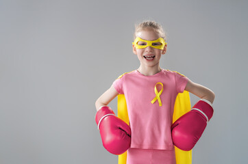 Child in boxing gloves with a yellow ribbon
