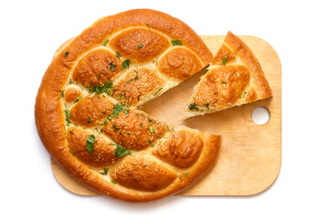 Pie with a cut slice on a wooden cutting board. Homemade cakes with herbs and sesame seeds on a white background.