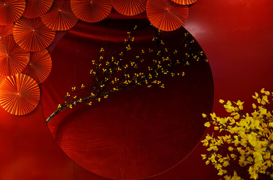 Photo shooting red background for Lunar New Year with yellow flowers and fan shaped decoration