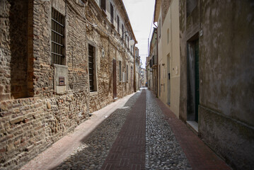 Fototapeta na wymiar Narrow stone-paved street, Italy, ancient architecture, old town, travel in Italy, Europe, tourism, background