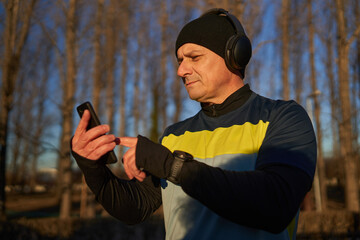 Runner with headphones choosing playlist