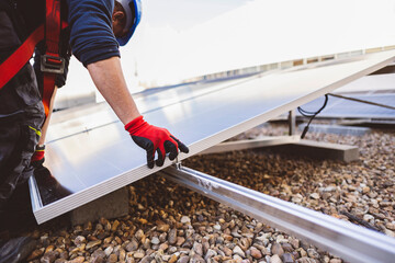 Detail shot of a solar panel installer placing the solar panel on the roof