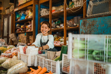 female green grocery seller putting products that she sale into basket
