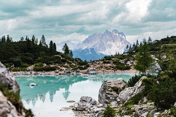 Naklejka na ściany i meble View over turquoise lake Sorapis in the Dolomites towards the Three Peaks in the Italian Alps on an overcast day