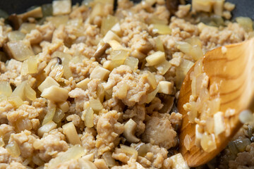 鶏ミンチと玉ねぎ(粗みじん切り)とエリンギをフライパンで炒める調理シーン。
