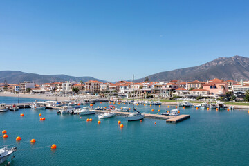 Naklejka na ściany i meble Peloponnese Paralio Astros port, Arcadia Greece. Aerial drone view of town, moored boat, buoy in sea