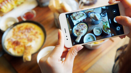 Take a photo of a smartphone for lunch or dinner. Woman taking picture with phone. Posting or...