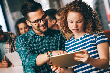 Group of young multi-ethnic startup business team collaborating on project in modern office