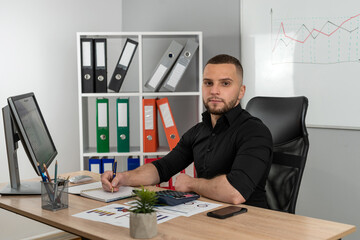 Man working and analyzing financial reports project at modern office