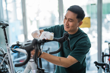 activity of man holding foaming sponge while cleaning bicycle with indoor background