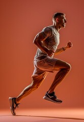 Fototapeta na wymiar Portrait of young male professional athlete in uniform training running isolated over orange studio background. Maintaining health and strength. Concept of sport, healthy lifestyle, motion, ad.